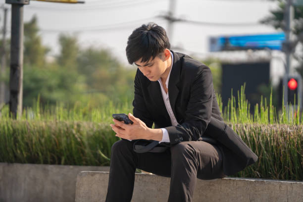 istock Businessman using mobile phone to make business call while commuting to office 2197720969