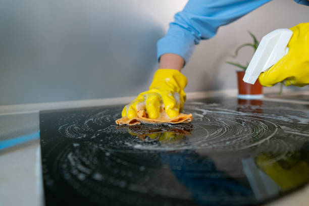 istock Woman doing housework cleaning kitchen tiles with cleaning products while wearing protective gloves. 2197723477