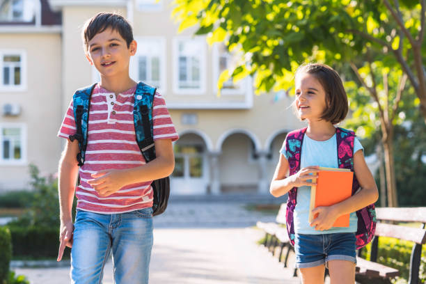 istock Children share a delightful moment in the schoolyard 2197723707