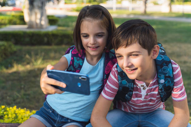 istock Kids taking a selfie together sitting on the grass 2197723745