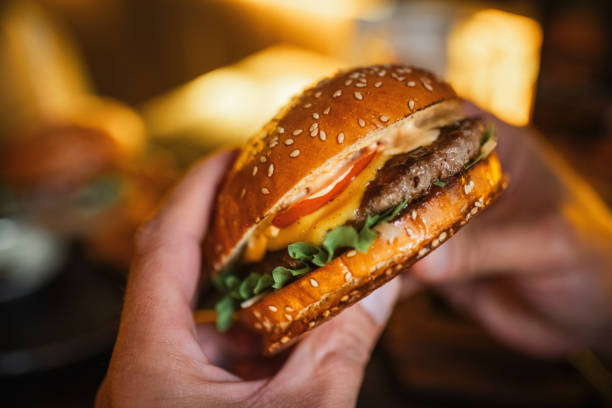 istock Man eating burger in a cafe or pub 2197723761