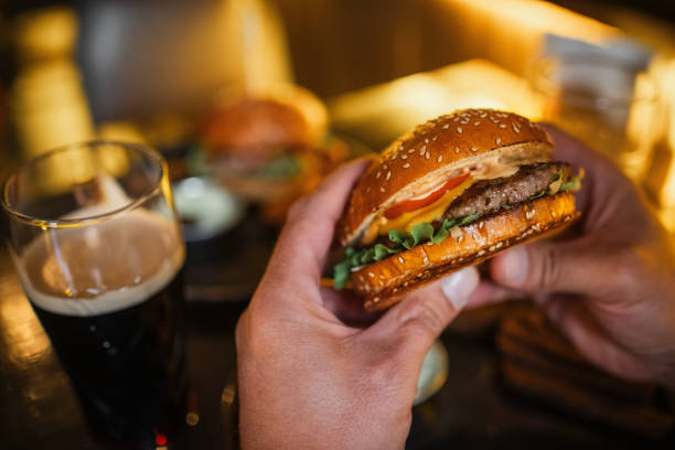 istock Man eating burger in a cafe or pub 2197723763