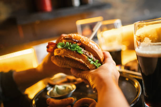 istock Woman eating burger in a cafe or pub 2197723799