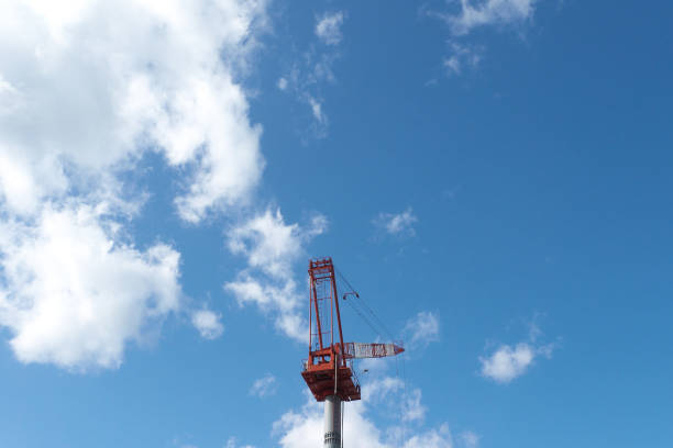 A crane at a construction site and cloudy sky background in Japan