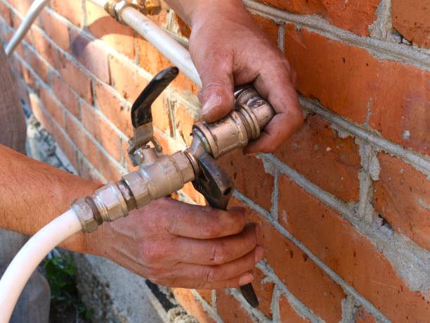 istock working with a wrench on a water pipe on an external brick wall 2197730059