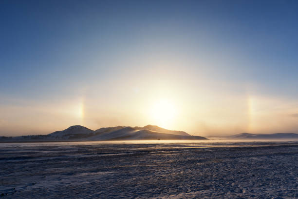 The beautiful sunset on the snowy grassland, with a halo of light