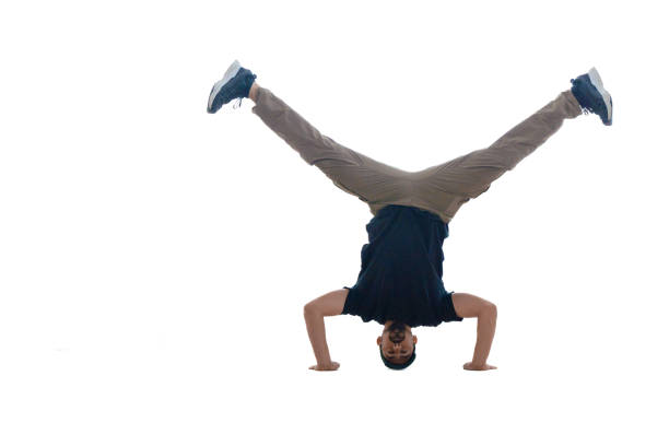 Young muscular man doing handstand on the top of the rock in a quarry.