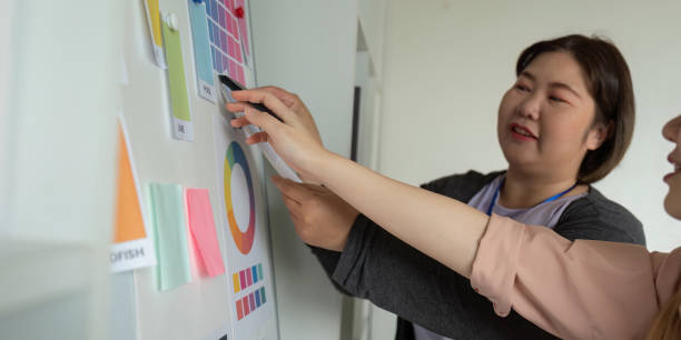 istock Graphic design team selecting color swatches from a presentation board in a modern office. 2197731307