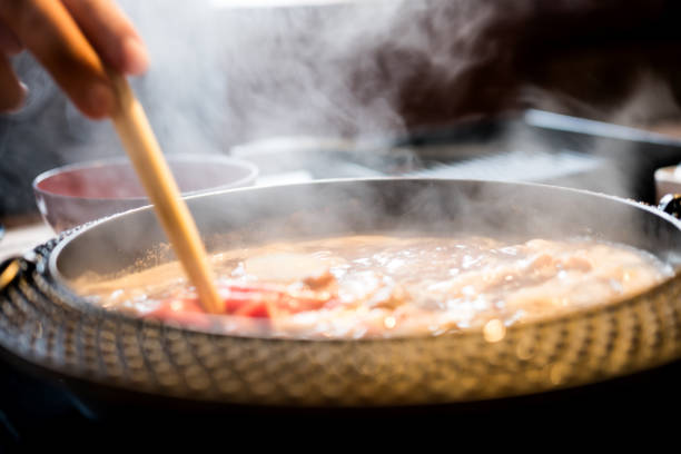 istock Holding sliced pork using chopsticks on hot pot with smoke for Japanese hot pot 2197732168