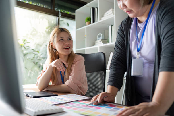 istock Graphic design team sharing ideas and reviewing color palettes in a bright office. 2197733030