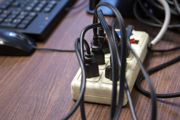 istock Old and damaged electric adapter power plug has many appliances are plugged outlet socket concept of risk danger overloaded current electrical. 2197733169
