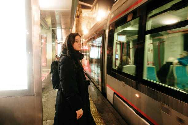 istock Young woman at a tram stop at night 2197733496