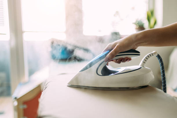istock Ironing Clothes with Moden Steam Iron in Bright Daylight at Home 2197734752