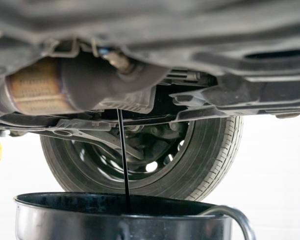 istock A mechanic drains a car's used engine oil. 2197738283