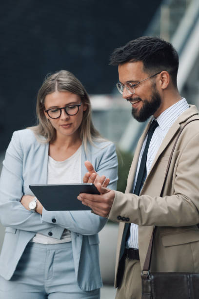 istock Business people having conversation about work on tablet outdoors 2197738675
