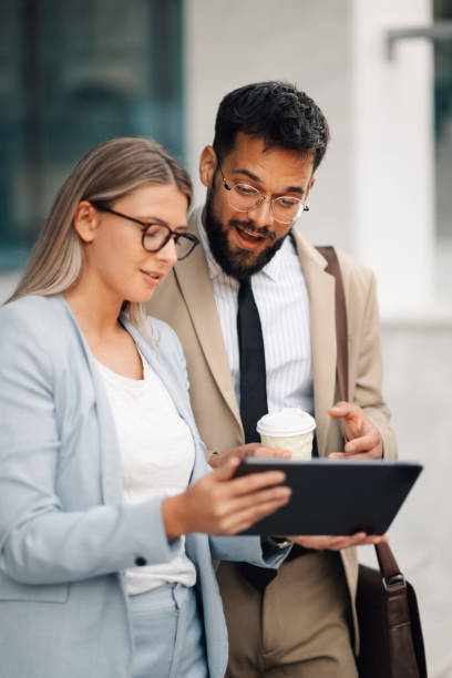 istock Business people having conversation about work on tablet outside office building 2197738726