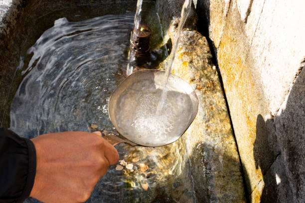 Isolated traditional japanese bamboo wooden laddle, in Arashiyama . Purification water fountain chozubachi.
