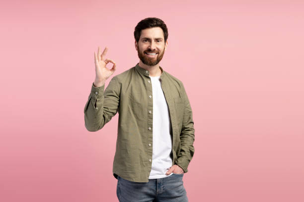 istock Happy Latin bearded man making ok gesture posing at camera against pink background 2197740283