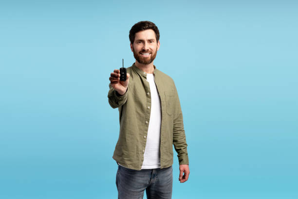 istock Young overjoyed smiling cheerful man wearing casual t shirt, holding car keys in studio 2197740407
