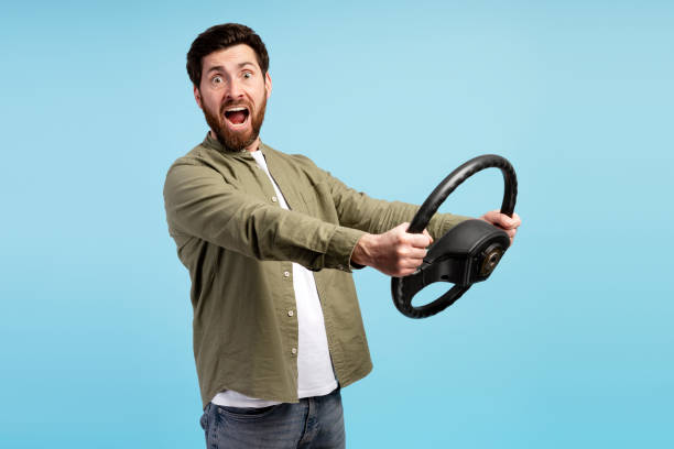 istock Young man driver screaming holding steering wheel, looking at camera 2197740429