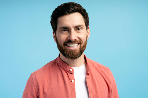 istock Smiling bearded Latin young man in casual clothes looking at camera, isolated on blue 2197740450