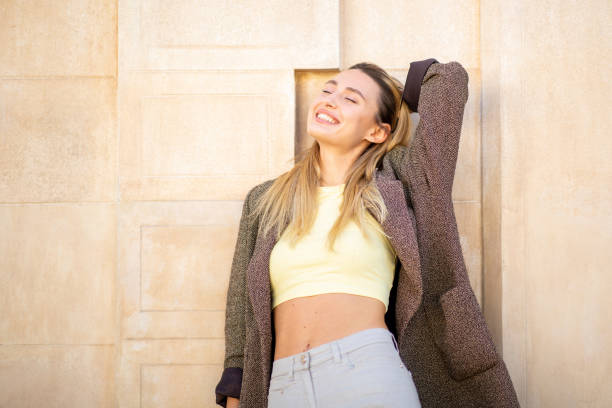 Beautiful woman posing outdoors with her eyes closed and hand behind head