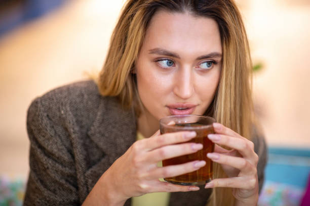 istock young woman looking away while drinking herbal tea at cafe 2197743735