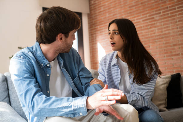 istock Man and woman sitting on a sofa at home, facing serious relationship difficulties after betrayal and infidelity, struggling with loss of love, financial stress, and making tough decisions about their future together 2197743767