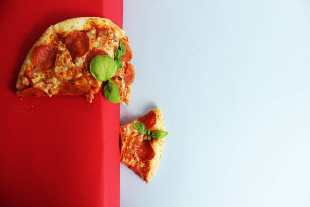 Pizza slices with basil on a red white background. Flying Pizza.