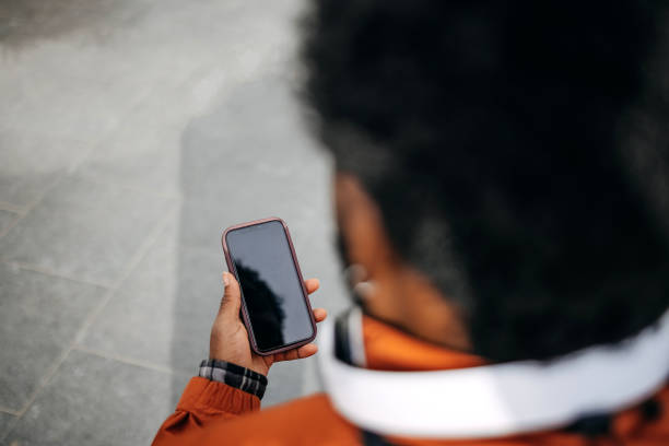 istock Black person using mobile phone outdoor with blank screen 2197748611