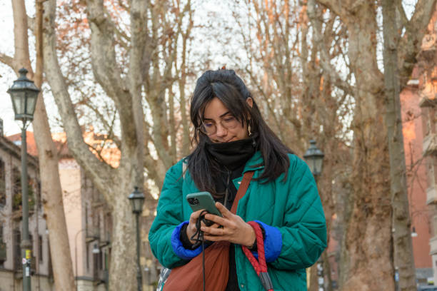 istock Front-Facing Portrait of Woman Using Smartphone with Autumn Trees 2197749683