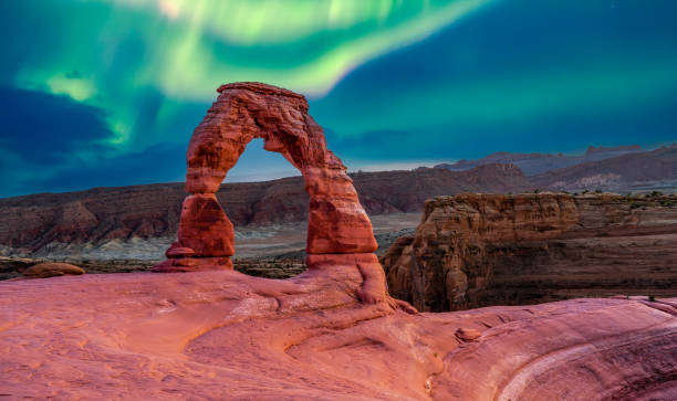 Experience the breathtaking northern lights at Delicate Arch in Arches National Park, Utah, with vibrant skies illuminating the iconic sandstone formation. This stunning natural wonder showcases the beauty of the American Southwest’s rugged desert landscape and dramatic rock formations.