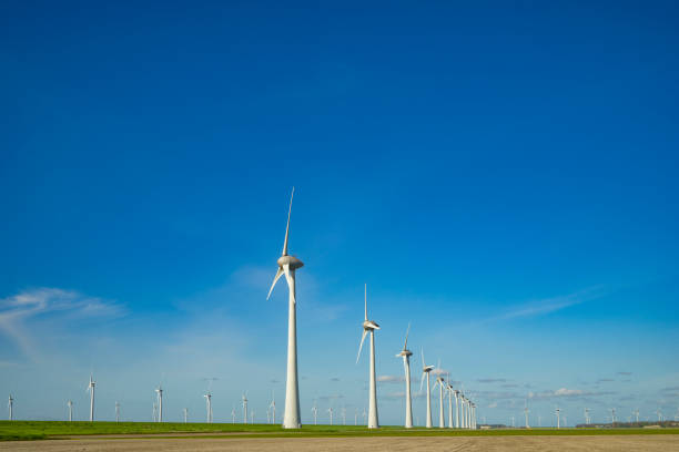 Wind turbines producing sustainable renewable energy in a wind park in Flevoland, The Netherlands, during springtime.