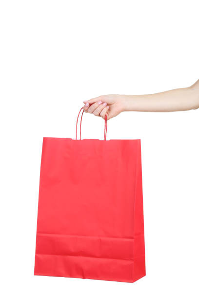Female hand holding red shopping bag on white background