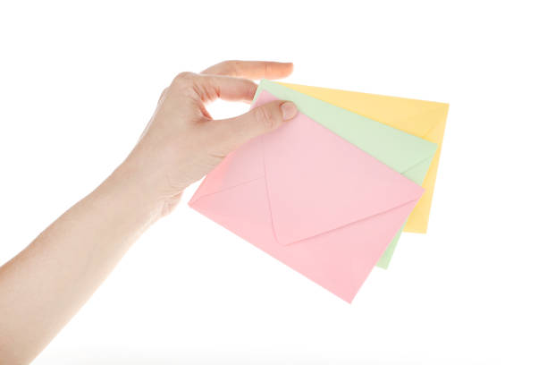 istock Female hand with colorful paper envelopes on white background 2197752897
