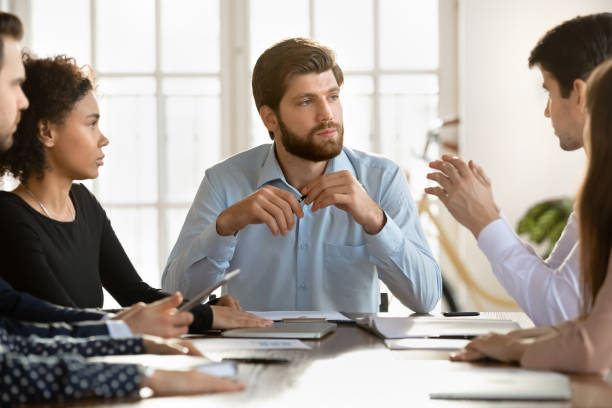istock Serious young startup leader man holding meeting with diverse team 2197753101