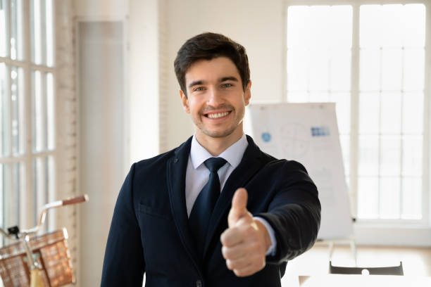 istock Cheerful handsome young businessman in formal suit posing in office 2197753850