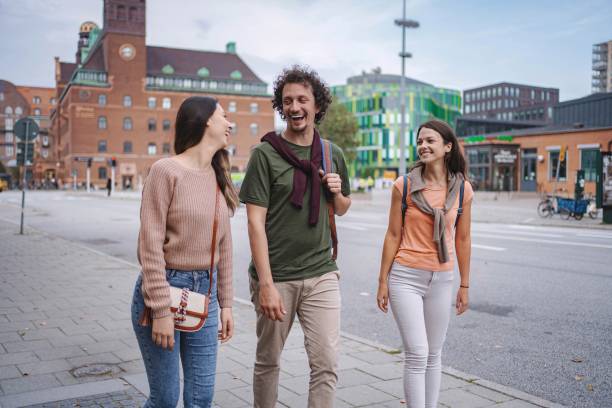istock Three young adults walking and talking in malmo city center 2197753931