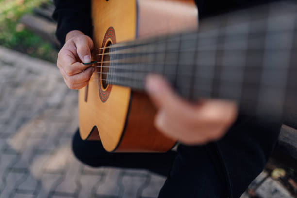 istock Musician playing acoustic guitar outdoors in park 2197757385