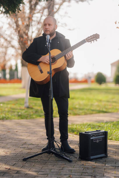 istock Musician playing acoustic guitar and singing in a park 2197757771