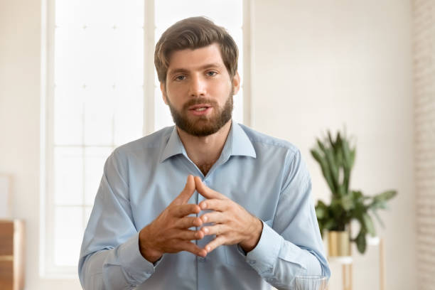 istock Serious handsome young business blogger man speaking at camera 2197758067