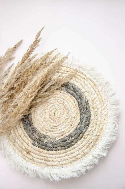 istock A round woven placemat, and dry spikelets on a light beige background.dry spikelets. Mock up. Concept of home comfort and interior elements. 2197759535