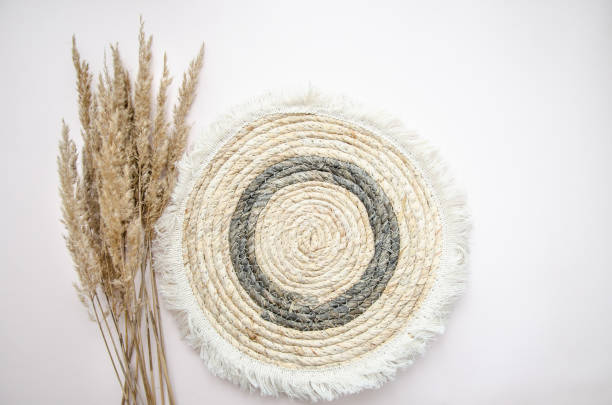 istock A round woven placemat, and dry spikelets on a light beige background.dry spikelets. Mock up. Concept of home comfort and interior elements. 2197759539