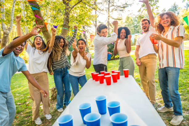 istock Happy friends playing beer pong outdoors in a park 2197760882