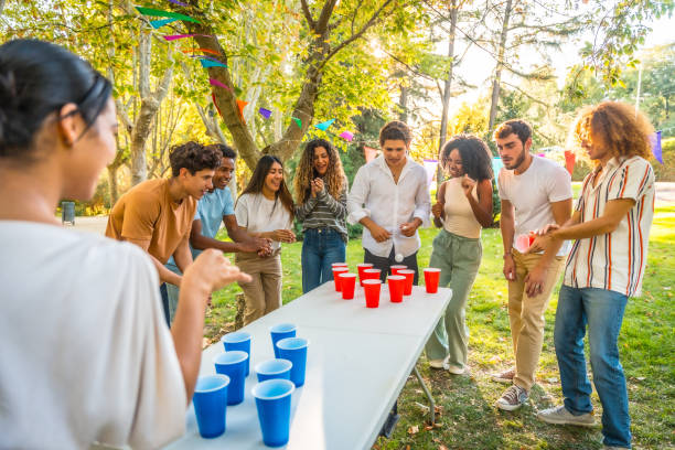 Friends playing beer pong outdoors in a park
