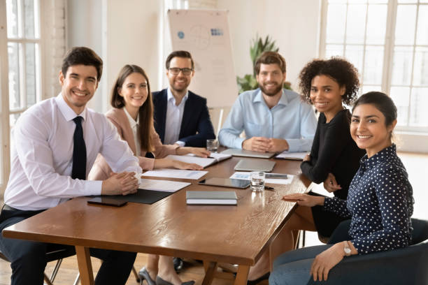 istock Happy young diverse team of professionals posing at office table 2197760945