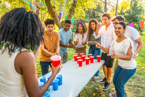 istock Friends playing beer pong outdoors in a park during a sunny day 2197761045