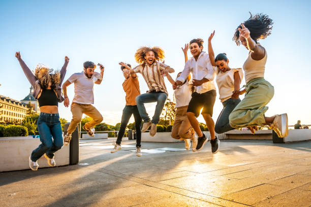 istock Happy young people jumping together outdoors at sunset 2197762144