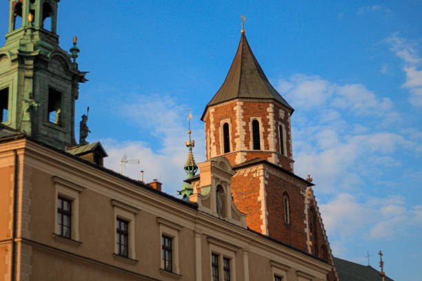 A close view of a red-brick church with white stone accents, highlighted by a deep blue sky. The elegant structure is a testament to Poland's rich architectural history