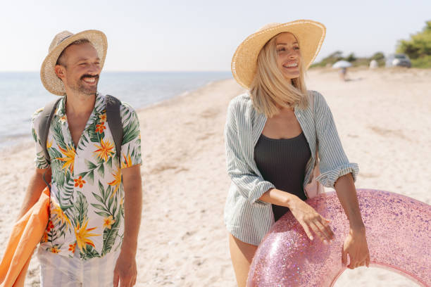 istock Smiling couple arriving at the beach 2197768245